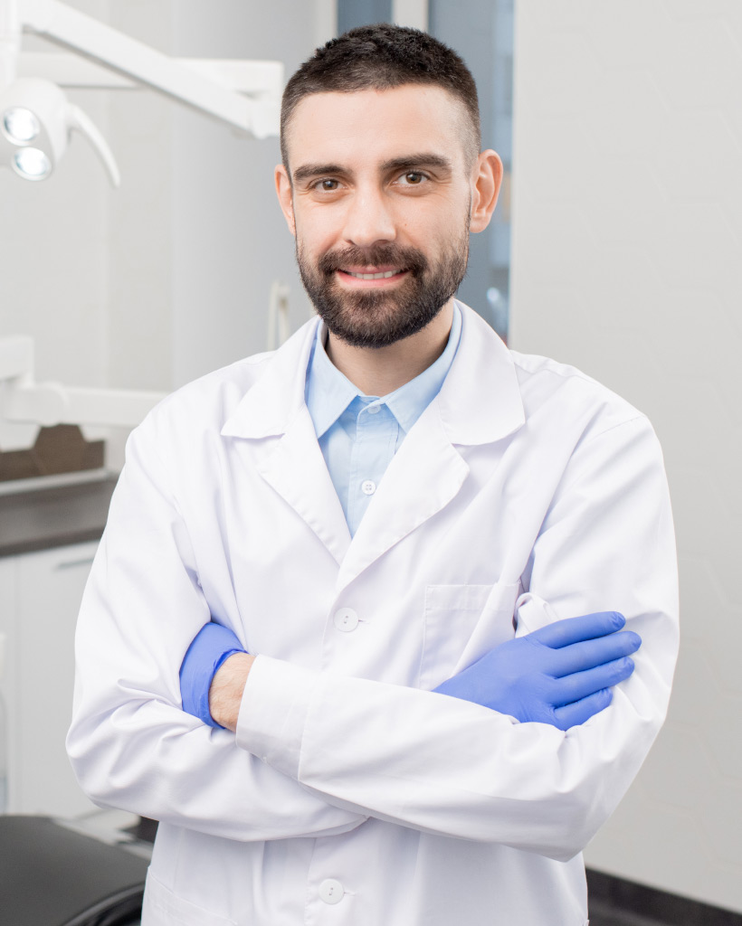 happy young bearded professional dentist in gloves